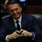 El presidente brasileño, Jair Bolsonaro, muestra un corazón con sus dedos durante su toma de posesión en el Parlamento.-MARCELO CHELLO (EFE)