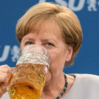 La cancillera alemana bebe una jarra de cerveza tras participar en un mitin en Múnich.-MATTHIAS BALK / AFP