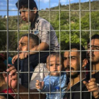 Refugiados e inmigrantes esperan tras una verja, en un campo de fútbol, a poder ser registrados, en Mitilene, este martes.-Foto: AP / SANTI PALACIOS
