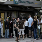Ciudadanos griegos esperando la apertura de los bancos.-Foto: AFP / ARIS MESSINIS