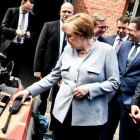La cancillera alemana Angela Merkel observa armas de fuego durante su visita al Departamento Federal de la Policía en Pasewalk.-EFE / FILIP SINGER