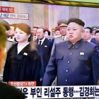 Dos personas miran en una gran pantalla de televisión la retransmisión de la ceremonia de conmemoración, en una estación de trenes de Seúl (Corea del Sur).-Foto: AFP / JUNG YEONG-JE