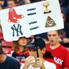 Un joven sostiene una pancarta con dibujos de 'emojis' en el partido de béisbol entre los New York Yankees y los Boston Red Sox de este domingo.-AFP