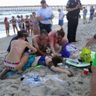 Los servicios de emergencia atienden a la joven de 14 años que ha sido atacada por un tiburón, este domingo en la playa de Oak Island.-Foto:  AP / STEVE BOUSER