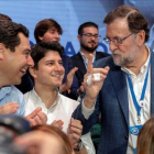 Mariano Rajoy habla con el líder del PP andaluz, Juanma Moreno, y el presidente de Nuevas Generaciones, Diego Gago, en la convención de Sevilla.-EFE / JULIO MUÑOZ