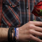 Iglesias sostiene una rosa con la mano en la que luce una pulsera podemista con el lema de Sánchez contra la abstención del PSOE en la investidura de Rajoy.-JOSE LUIS ROCA