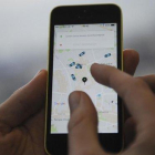 Un usuario de Uber utilizando la aplicación.-AFP / DANIEL SORABJI