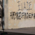 Un hombre barre el suelo ante un grafiti que reivindica la ’evasión’, en una calle de Santiago de Chile.-CLAUDIO REYES (AFP)