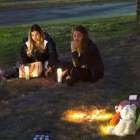 Unas jóvenes encienden velas en memoria de las víctimas del tiroteo en Burlington.-AFP / GETTY / KAREN DUCEY