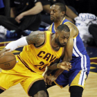 El jugador de los Warriors de Golden State Andre Iguodala (dcha) intenta evitar la entrada de LeBron James (izq), de los Cavaliers de Cleveland, durante el tercer encuentro de las finales de la NBA.-Foto: EFE