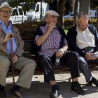 Tres jubilados descansan en un banco de un parque en Valencia.-MIGUEL LORENZO