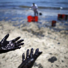 Voluntarios cargan cubos de petróleo de las costas de Santa Bárbara.-Foto: REUTERS / LUCY NICHOLSON