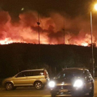 Una columna de llamas, al fondo, esta noche, en el gran incendio de Bormes-les-Mimosas.-EL PERIÓDICO (@JOHANROUQUET / @INFOEMERG)