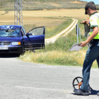 Un agente toma mediciones ante el turismo implicado en el accidente. / ÁLVARO MARTÍNEZ-