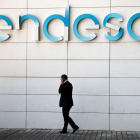 Un hombre camina bajo el logo de Endesa en la sede de la empresa en Madrid-ANDREA COMAS (REUTERS)