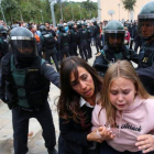 Una madre y su hija huyen tras la carga policial en Sant Julià de Ramis.-ALBERT GEA/REUTERS