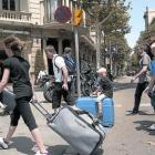 Turistas con maletas rumbo a su alojamiento.-JOAN CORTADELLAS