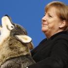 Angela Merkel, con un lobo de peluche con el que ha sido obsequiado en la convención de la CDU en Karlsruhe, este lunes.-AP / MICHAEL PROBST