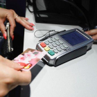Un cliente realizando un pago con un tarjeta en un comercio.-FERRÁN NADEU