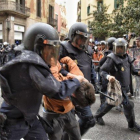 Dos policías con uno de los manifestantes detenidos en Via Laietana.-MANU MITRU