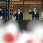 Emperor Akihito  waves to national flag-waving well-wishers with Empress Michiko,  Crown Prince Naruhito and Crown Princess Masako after delivering his speech marking his 85th birthday  his last birthday on the throne  at the Imperial Palace in Tokyo-KIMIMASA MAYAMA / EPA