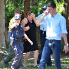 a policía atiende a una mujer en el lugar de los hechos, en la localidad de Cairns, en el noreste del Australia.-Foto:  AFP / ISAAC EGAN