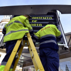 Dos operarios municipales trabajan en un panel informativo.-ÁLVARO MARTÍNEZ