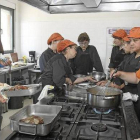 Carlos Soriano en la cocina junto a sus quince alumnas. / MANUEL BRÁGIMO-