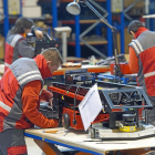Dos trabajadores de la empresa  Asti fabrican un vehículo de guiado automático.-ISRAEL L. MURILLO