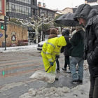 Un operario retira nieve en el centro de la capital con una pala.-MARIO TEJEDOR
