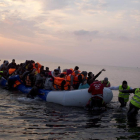 Varios voluntarios ayudan a un grupo de refugiaos a llegar a la costa, en la isla griega de Lesbos, el pasado marzo.-AP