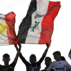 Aficionados de futbol sostienen banderas kurdas e iraquís en un partido de su selección. En una foto de archivo.-AFP / SAFIN HAMED (AFP)