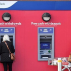 Dos mujeres retiran efectivo de cajeros automáticos de Tesco Bank en Liverpool.-PAUL ELLIS
