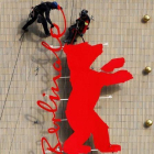 Unos operarios fijan el logo de la Berlinale en el cine Zoo Plast, una de las sedes del festival de Berlín, este miécoles.-REUTERS / FABRIZIO BENSCH