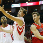 Víctor Claver (derecha) observa cómo Alexey Shved se hace con el balón, en el partido que han disputado los Trail Blazers y los Rockets.-Foto: AFP / SCOTT HALLERAN