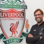 Jürgen Klopp posa junto al escudo del Liverpool en las dependencias de la ciudad deportiva de Melwood.-JOHN POWELL