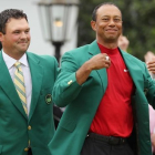 Tiger Woods recibe la chaqueta verde del anterior ganador Patrick Reed en la ceremonia del Masters.-LUCY NICHOLSON (REUTERS)