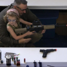 Un hombre muestra a una niña cómo coger una escopeta de aire comprimido durante el NRA Youth Day, en la reunión anual de la NRA, en Houston, en el 2013.-/ REUTERS / ADREES LATIF