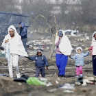 Refugiadas caminan con sus hijos por el campamento de Calais durante su desmantelamiento.-EFE / ARCHIVO