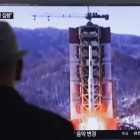Un hombre observa imágenes televisivas de archivo del lanzamiento de un misil norcoreano, este jueves, en Seúl.-AFP / AHN YOUNG-JOON
