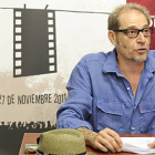 El director del certamen, Javier Muñiz, frente al cartel ganador. / VALENTÍN GUISANDE-