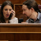 Pablo Iglesias muestra el móvil a Irene Montero durante el pleno en el Congreso.-JOSÉ LUIS ROCA