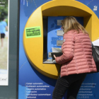 Una mujer saca dinero del cajero automático.-MÓNICA TUDELA