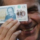 El gobernador del Banco de Inglaterra, Mark Carney, muestra el nuevo billete de plástico de 5 libras.-STEFAN WERMUTH