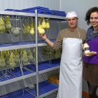 Salvatore Voccia y Ana Vaquero muestran los quesos calabaza (zucca) y de trenza en la cámara de curación de la quesería, en Portillo (Valladolid).-MAR TORRES