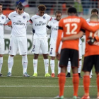 Los jugadores del PSG y del Lorient, durante el minuto de silencio previo al partido-AFP / JEAN-SEBASTIEN EVRARD