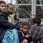 Un mujer migrante rodeada de niños, sentados junto a una valla durante una protesta por las penosas condiciones del campo de refugiados y contra el cierre del paso fronterizo de Idomeni (Grecia), este jueves.-AP / GREGORIO BORGIA