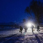 Un grupo de refugiados caminan de noche entre la nieve cerca de la localidad serbia de Miratovac.-AFP / DIMITAR DILKOFF