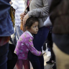 Una niña mexicana con su madre espera con otros inmigrantes en la frontera la respuesta a la solicitud de asilo político en EEUU.-GREGORY BULL (AP)