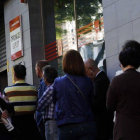 Un grupo de ciudadanos esperan ante una oficina de empleo en Madrid, el pasado mayo.-Foto: AGUSTÍN CATALÁN
